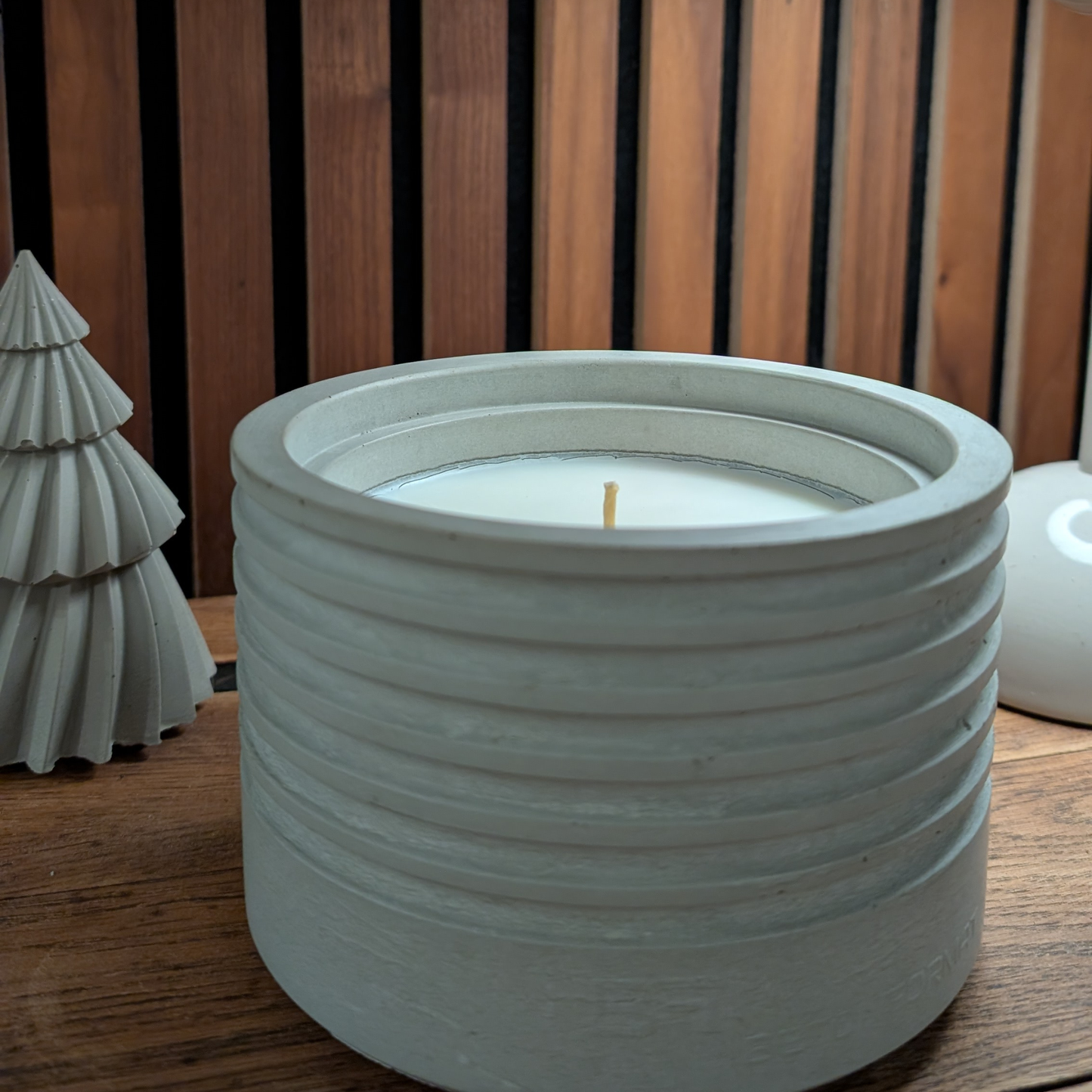 Indoor Kolbenfeuer als Wohnzimmer-Deko auf Holzregal vor warmer Holzwand